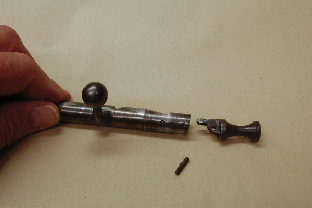 Removing the rear bolt pin drops the safety out for cleaning. A second pin frees the mainspring, but only remove this to replace the firing pin.